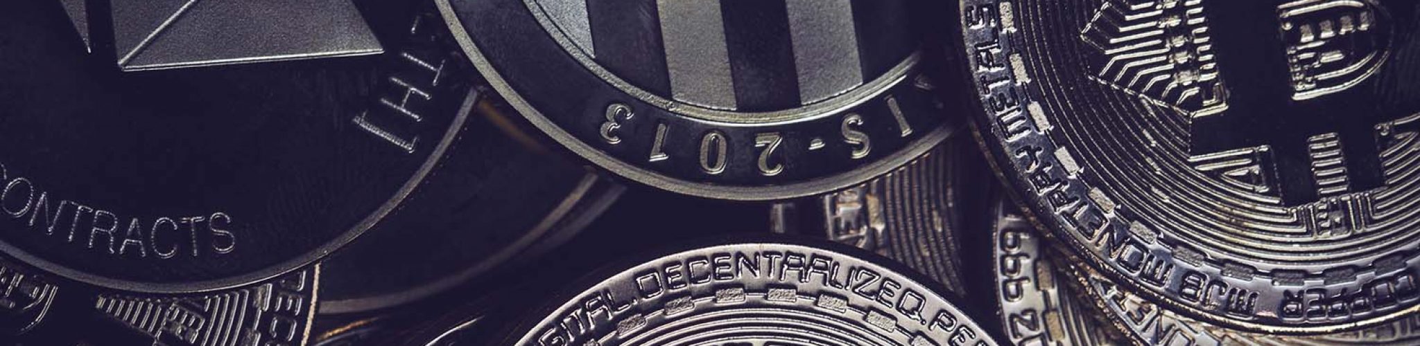 horizontal desaturated top view closeup of litecoin Ethereum and bitcoins metallic pile of coins textured background